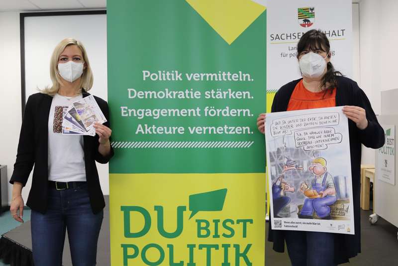 Anne Meyer von der Landeszentrale übergibt Kathrin Flecken vom Verein Jugendweihe e.V. Sachsen-Anhalt Plakate und Postkarten der Kampagne „Facts First“.