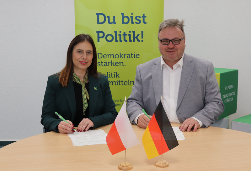 Karolina Kolbuszewska, Direktorin des „Museums – Haus der Familie Pilecki“ im polnischen Ostrów Mazowiecka, und Maik Reichel, Direktor der Landeszentrale für politische Bildung Sachsen-Anhalt, unterzeichnen die Kooperationsvereinbarung.